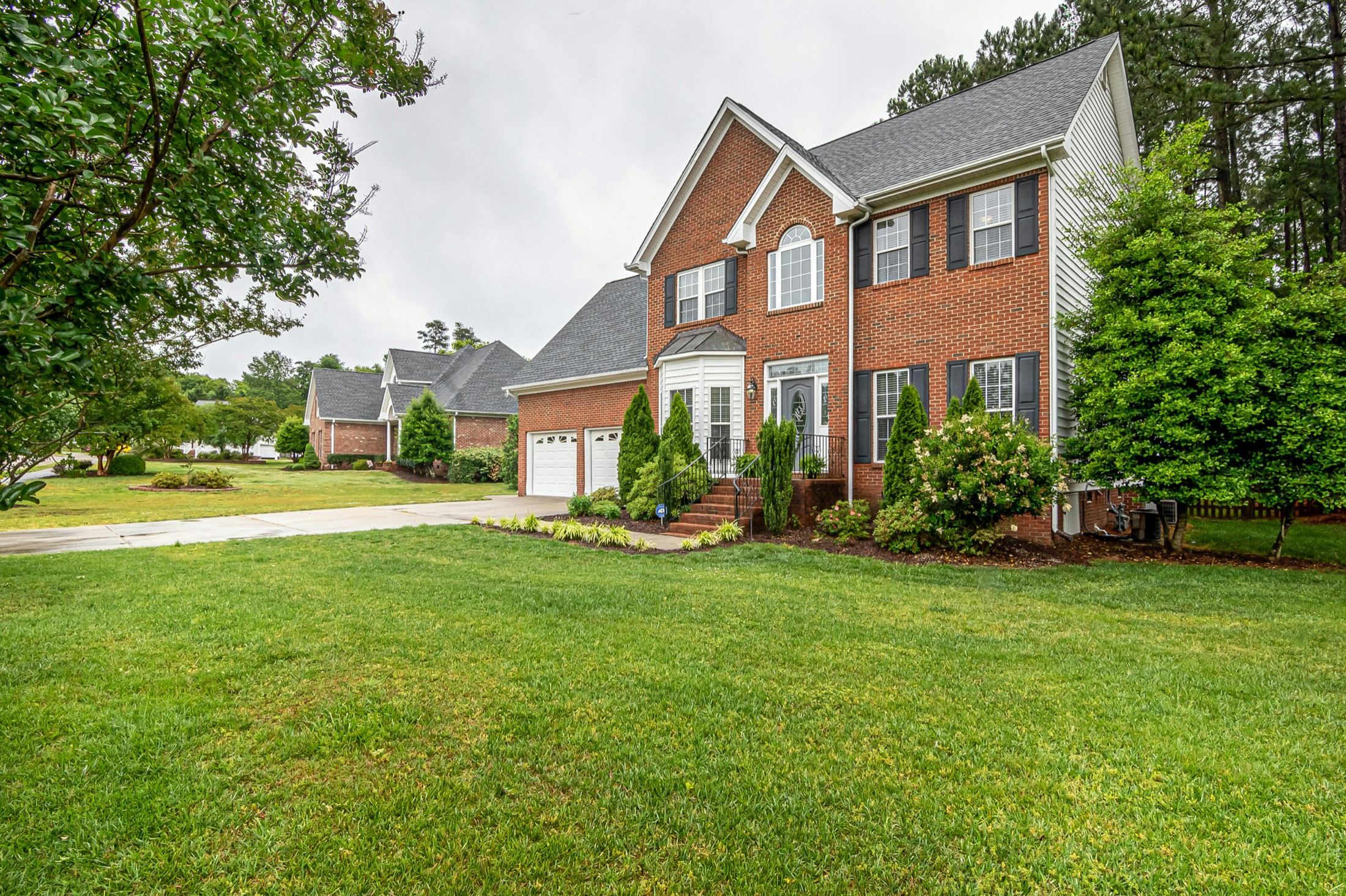 Well-kept brick home with manicured lawn and foundation plantings